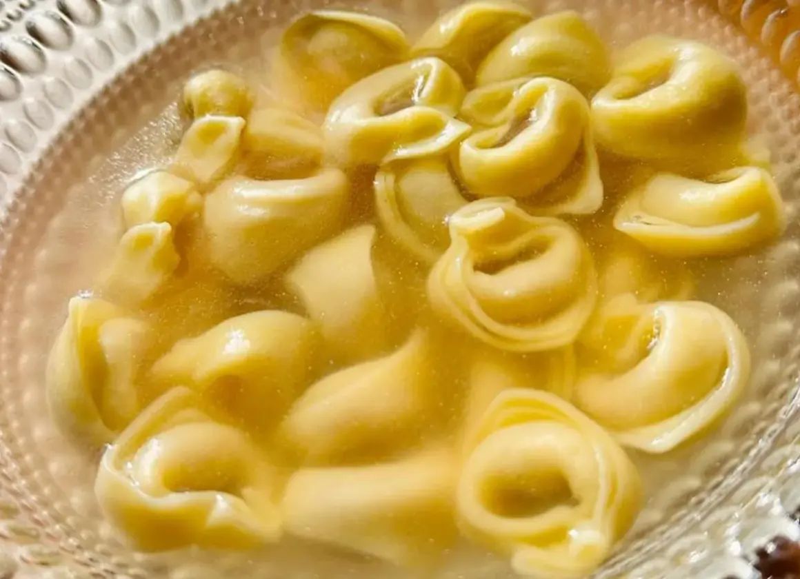 Un primo piatto caldo e confortante: tanti tortellini in brodo dorato, pronti per essere gustati.
