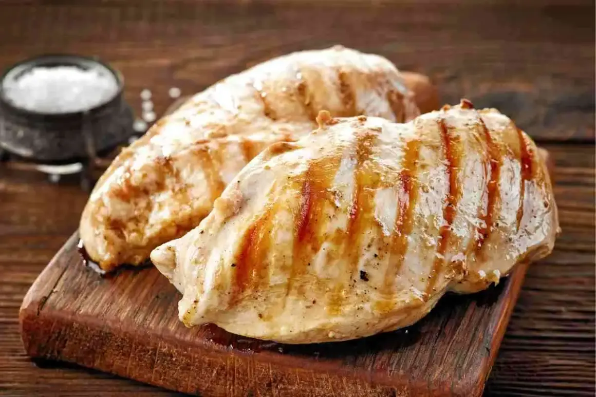 Petto di pollo alla griglia, perfetti secondi di carne da preparare in anticipo. Un contorno di sale completa l'immagine.