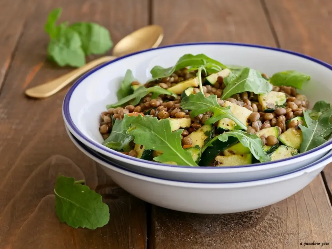 Insalata di lenticchie con zucchine e rucola, un piatto fresco e saporito, pronto per essere gustato.