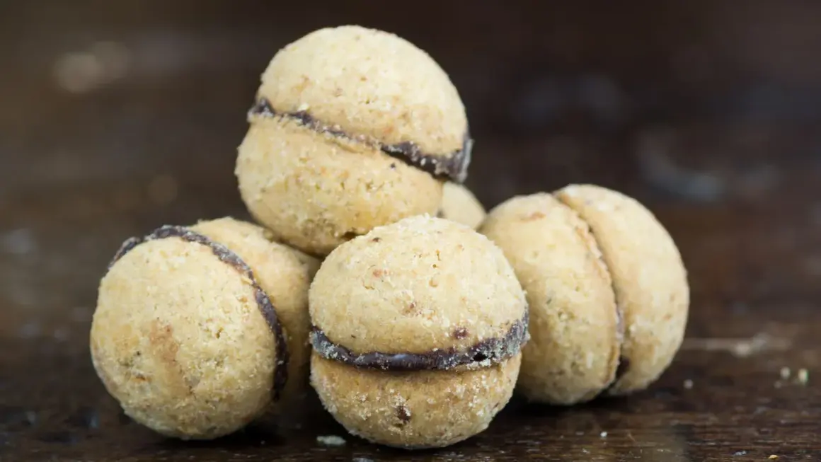 Baci di dama, deliziosi biscotti alle nocciole con un cuore di cioccolato, pronti per essere gustati.