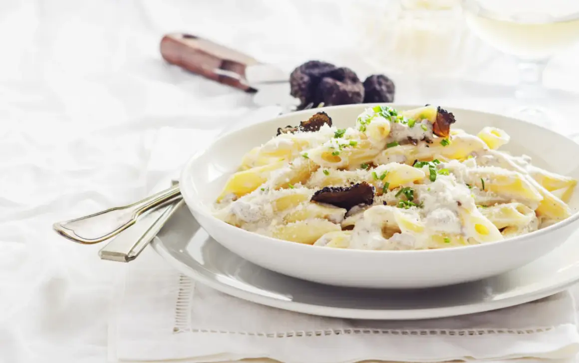 Penne cremose con funghi e tartufo nero, un piatto di pasta alla norcina che invita alla degustazione.