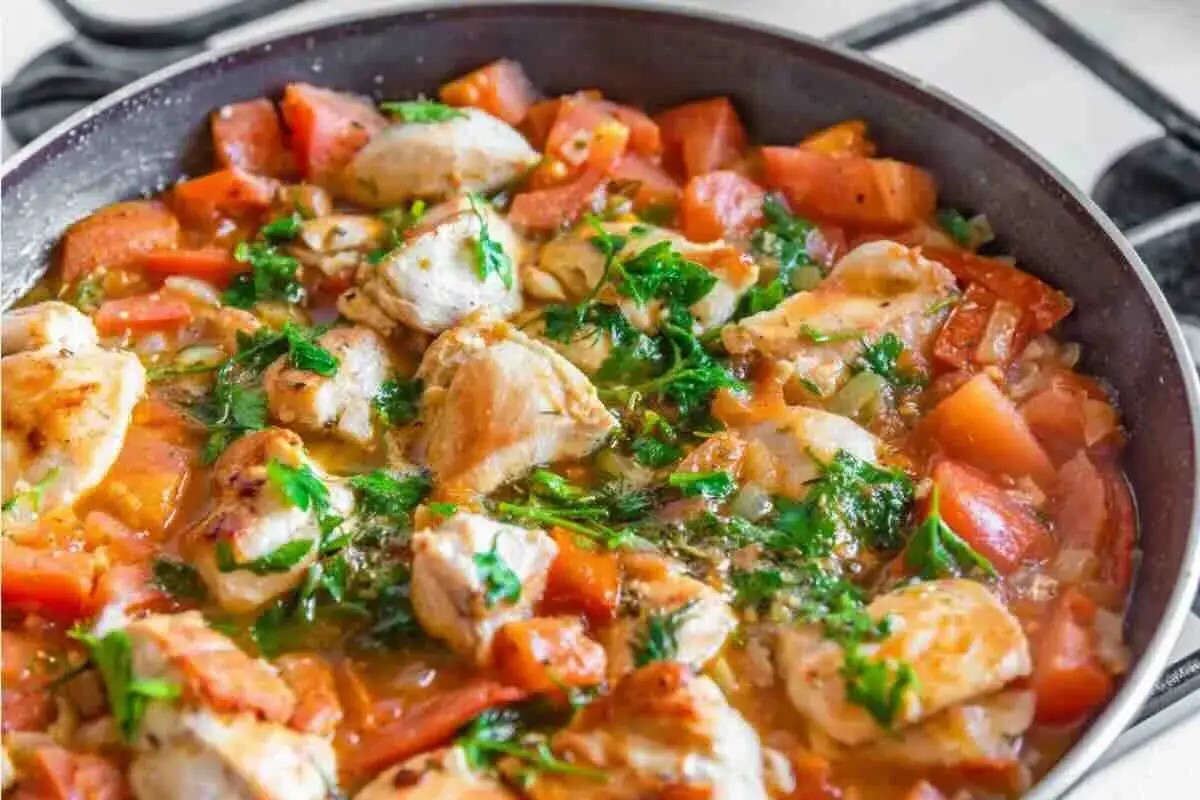 Succulento pollo alla pizzaiola in padella, con pomodoro fresco e prezzemolo. Un piatto saporito e invitante.