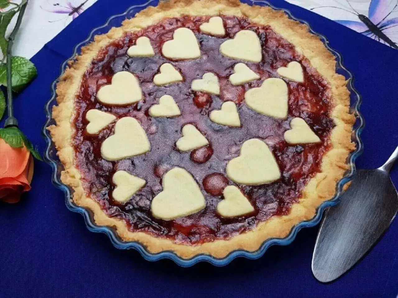 Deliziosa crostata di marmellata con decorazioni a forma di cuore, pronta per essere servita.