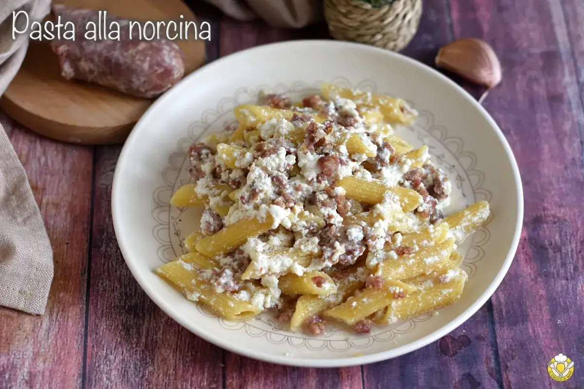 Piatto di pasta alla norcina con salsiccia sbriciolata e ricotta cremosa, un classico saporito.