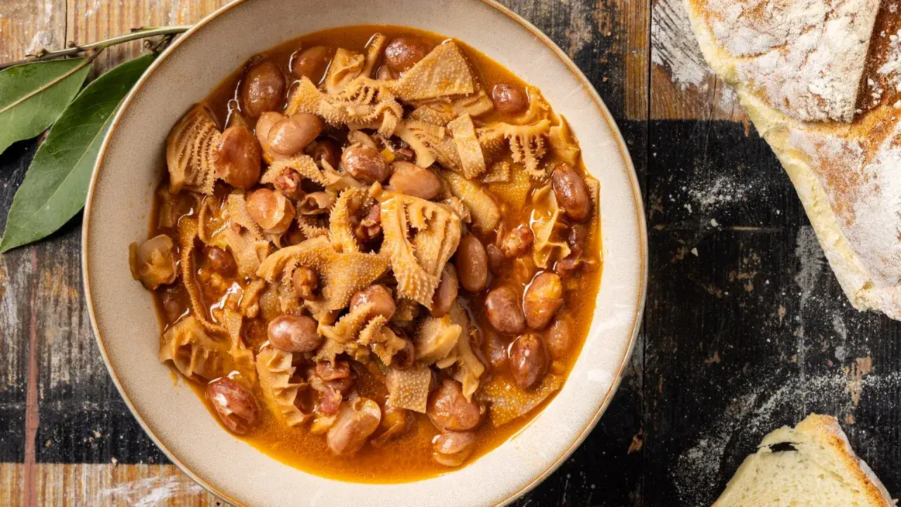 Un piatto fumante di trippa alla fiorentina con fagioli, pronto per essere gustato con pane fresco.