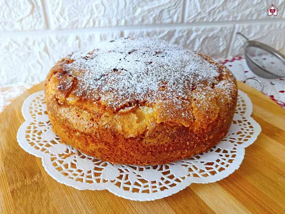 Una torta di mele umida e soffice, cosparsa di zucchero a velo, pronta per essere gustata.