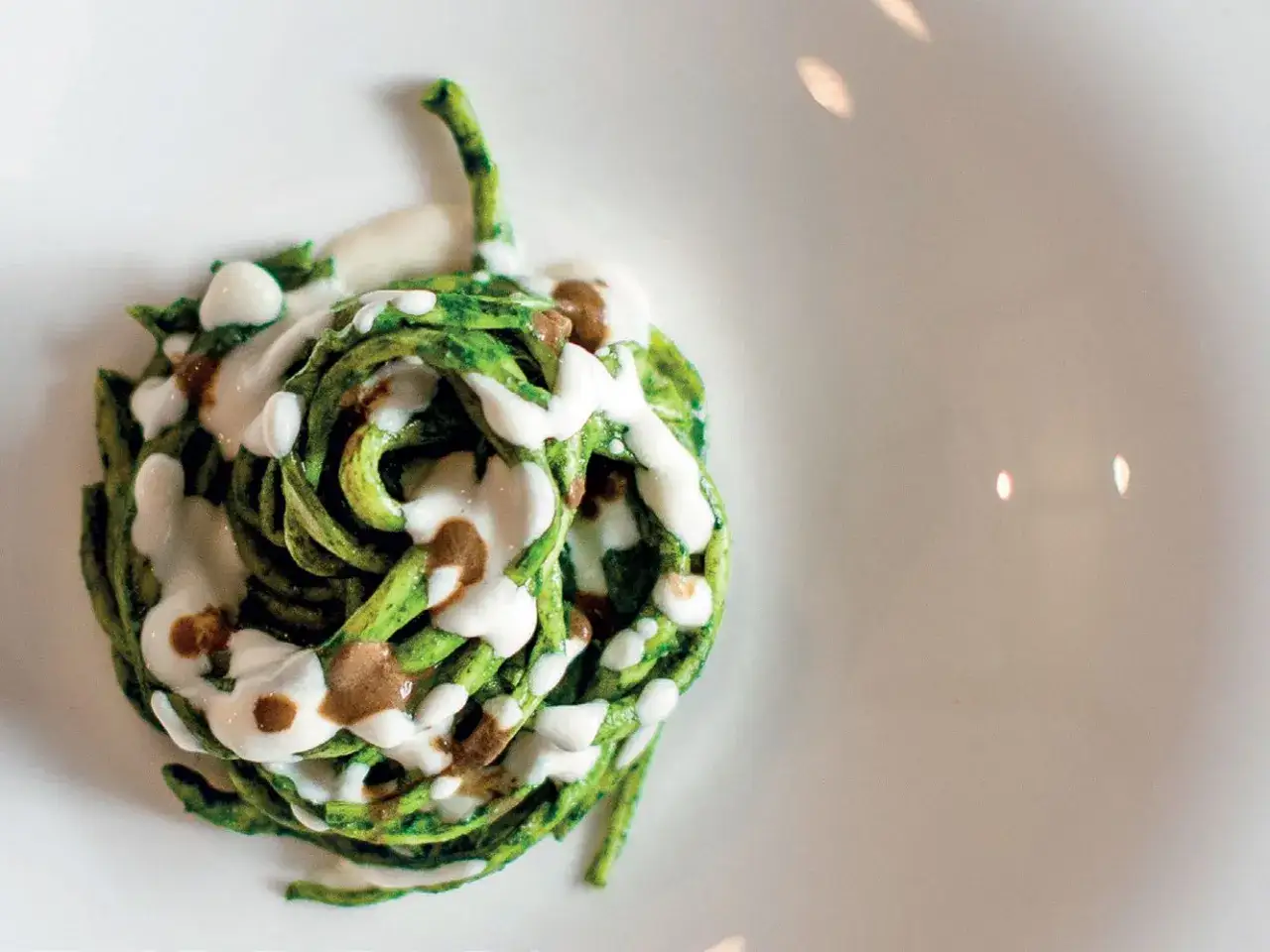 Pasta verde con crema e un filo di salsa scura, un'idea per cavolo nero ricette veloci.
