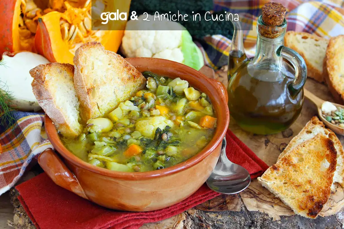 Un fumante passato di verdure in una ciotola di terracotta, accompagnato da crostini dorati e una bottiglia d'olio d'oliva.