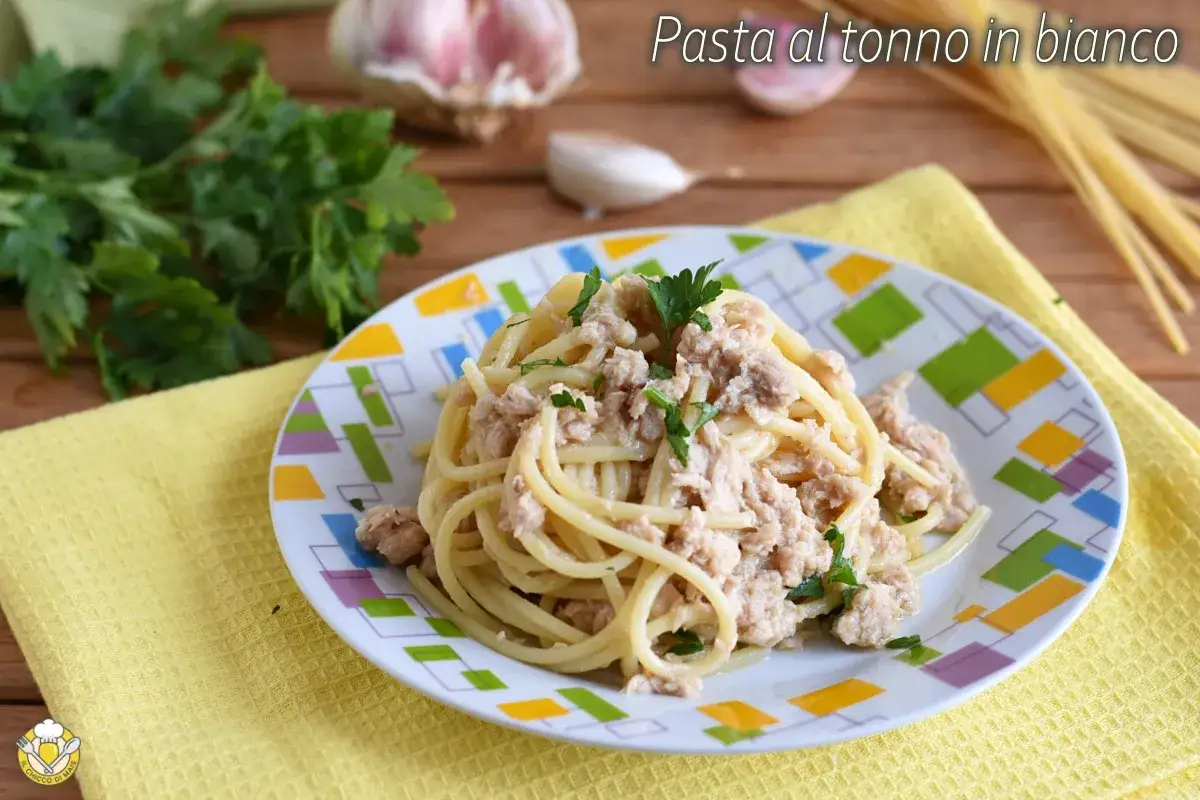 Un piatto di spaghetti conditi con tonno e prezzemolo, un classico della pasta al tonno in bianco.