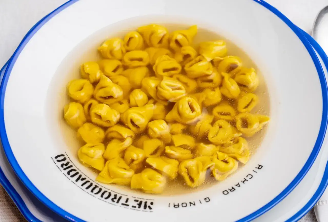Un piatto invitante di tortellini in brodo, un classico comfort food italiano, pronto per essere gustato.