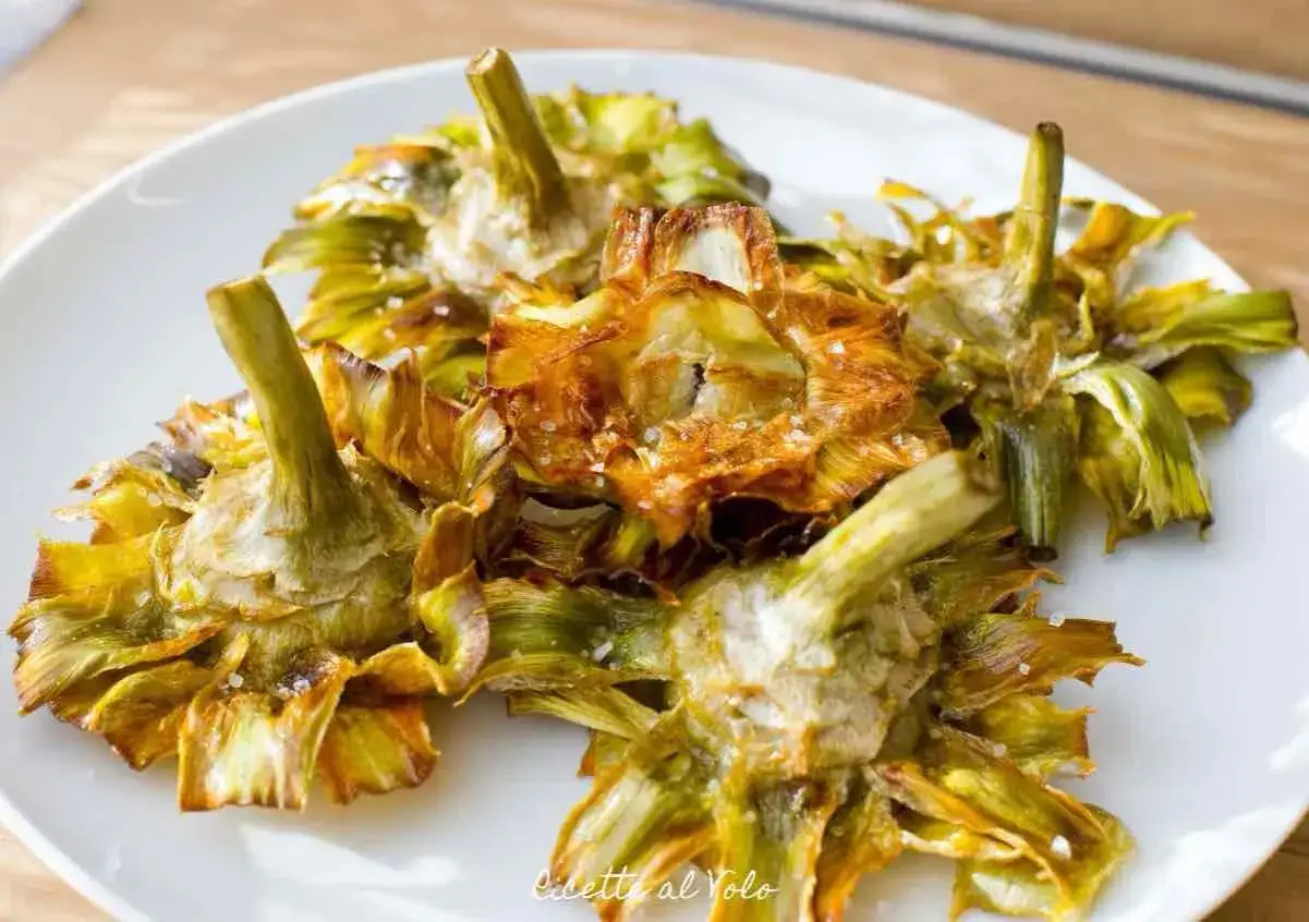 Un piatto di croccanti carciofi alla giudia, dorati e salati, pronti per essere gustati.