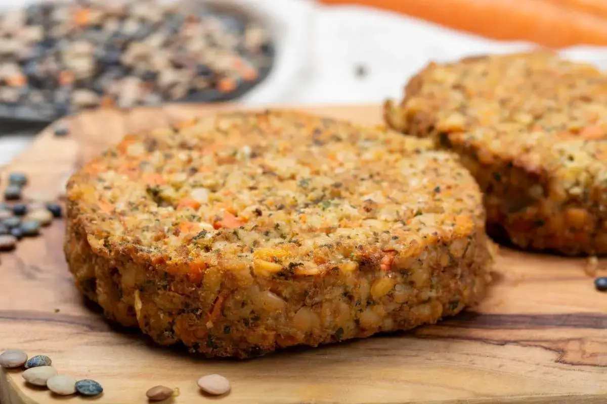 Due hamburger di lenticchie, ricchi di carote e spezie, pronti per essere gustati.
