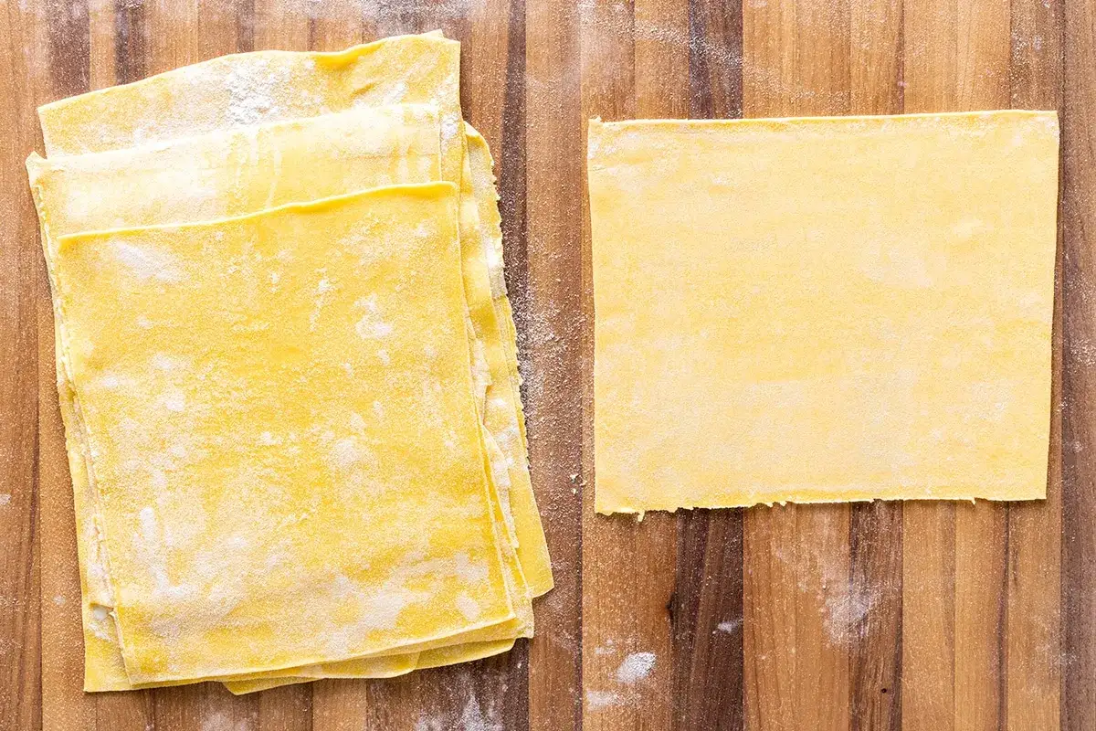 Fogli di pasta gialla, pronti per diventare deliziose lasagne fatte in casa.