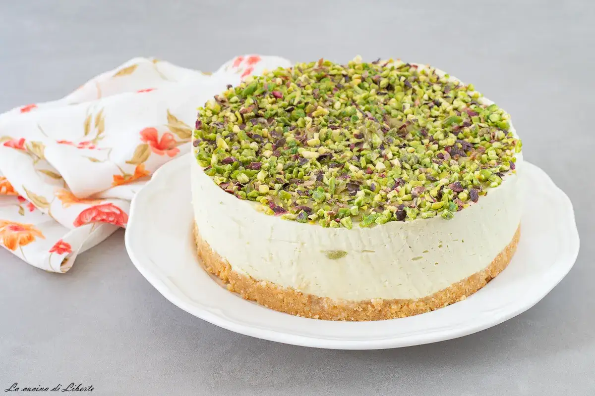 Delizioso cheesecake al pistacchio, con una base croccante e una crema vellutata, ricoperto da granella di pistacchi verdi.