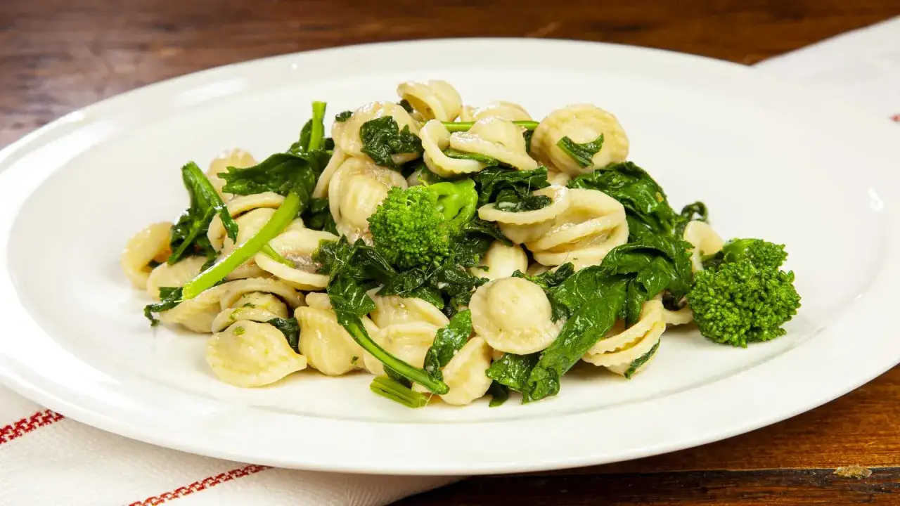 Un piatto invitante di orecchiette con cime di rapa, condite con verdure fresche e un filo d'olio.