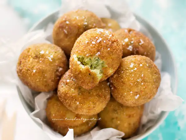 Polpette di zucchine e ricotta dorate e croccanti, cosparse di sale grosso. Una delizia da gustare!