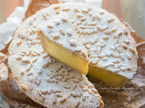 La crostata della nonna, con la sua crema gialla e i pinoli tostati, è un dolce che profuma di casa.