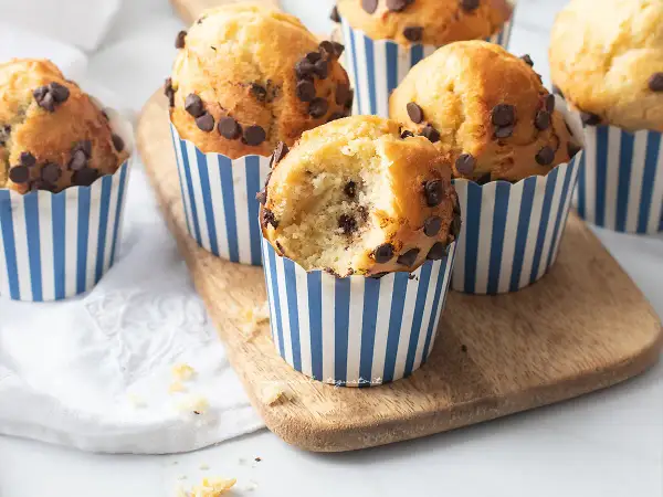 Muffin con gocce di cioccolato, perfetti per la friggitrice ad aria. Uno è stato morso, mostrando l'interno soffice.