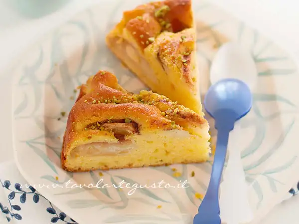 Fette di torta di mele senza burro, soffice e profumata, guarnita con pistacchi tritati.