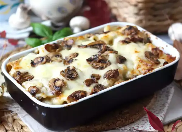 Un invitante pasta al forno con funghi e formaggio fuso, pronto per essere gustato.