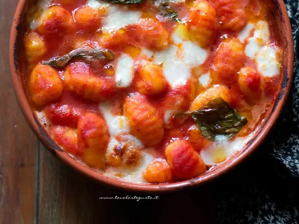 Gnocchi alla sorrentina fumanti in terracotta, con pomodoro filante e basilico fresco. Un abbraccio di sapori.