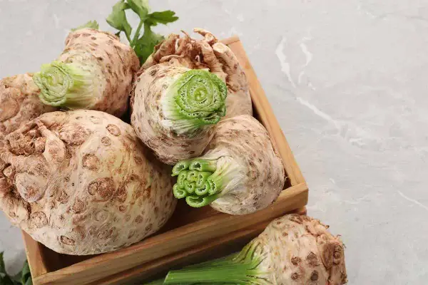Sedano rapa freschi in una cassetta di legno, pronti per gustose ricette.