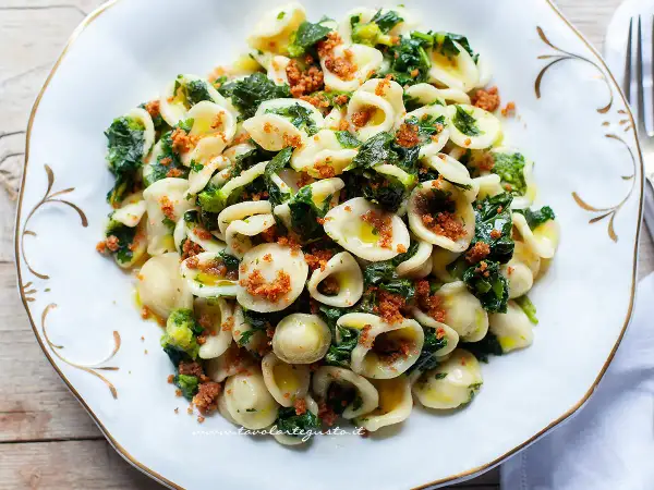 Un piatto invitante di orecchiette con cime di rapa, condite con olio d'oliva e pangrattato croccante.