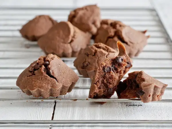 Deliziosi biscotti al cioccolato, alcuni interi e uno spezzato che rivela gocce di cioccolato fondente.