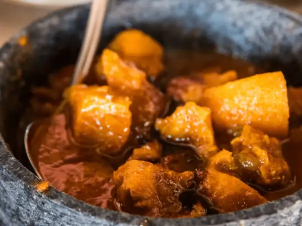 Un saporito spezzatino con patate, cotto lentamente e servito in una ciotola di pietra.