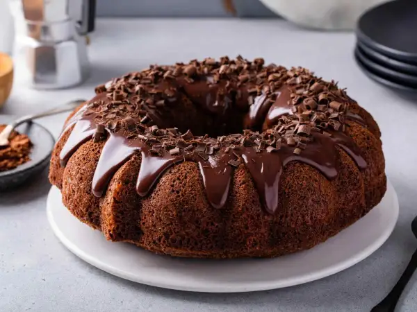 Torta al cioccolato con glassa lucida e riccioli di cioccolato, pronta per essere gustata.
