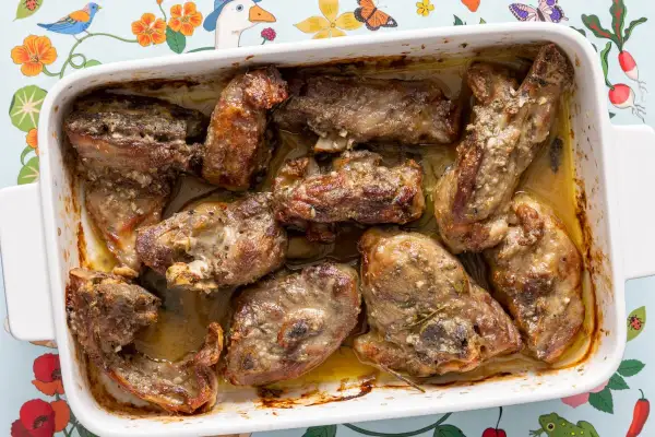 Pezzi succulenti di abbacchio alla romana cotti in teglia, con erbe aromatiche e succo saporito.